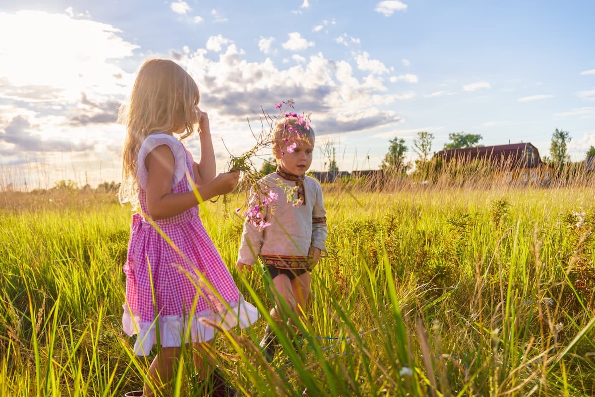 Ein Mädchen läuft im Sommer fröhlich über eine grüne Wiese